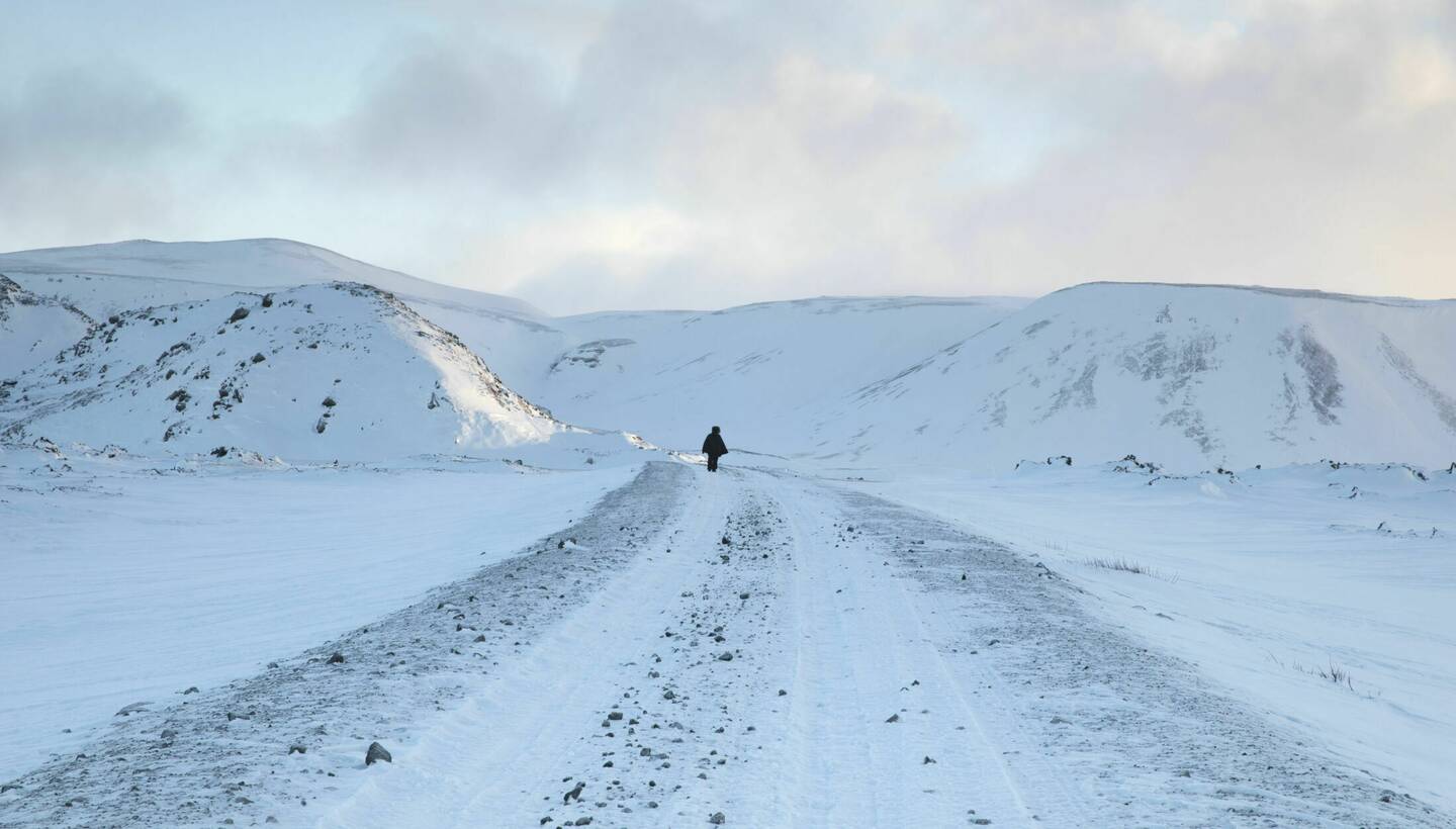 Photograph of a snowy scene with a figure in the distance.